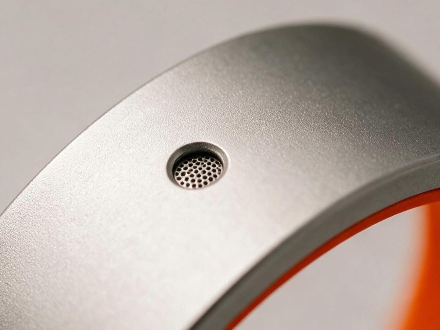 Extreme macro close-up of the microphone mesh on the Rhyme Devices R1, centered in frame